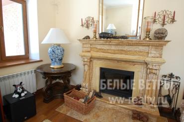 Камин отделан травертином с французской топкой