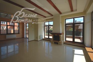 Гостиная с камином и выходом на террасу, переходящая в зону столовой